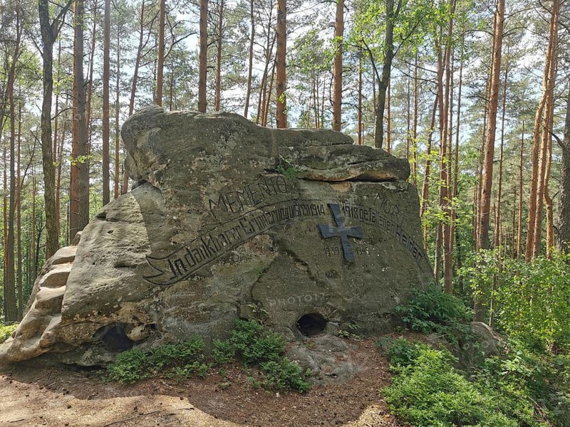 Large rock with inscription, war memorial in a light-flooded forest, hiking in the Franconian Forest nature park Park