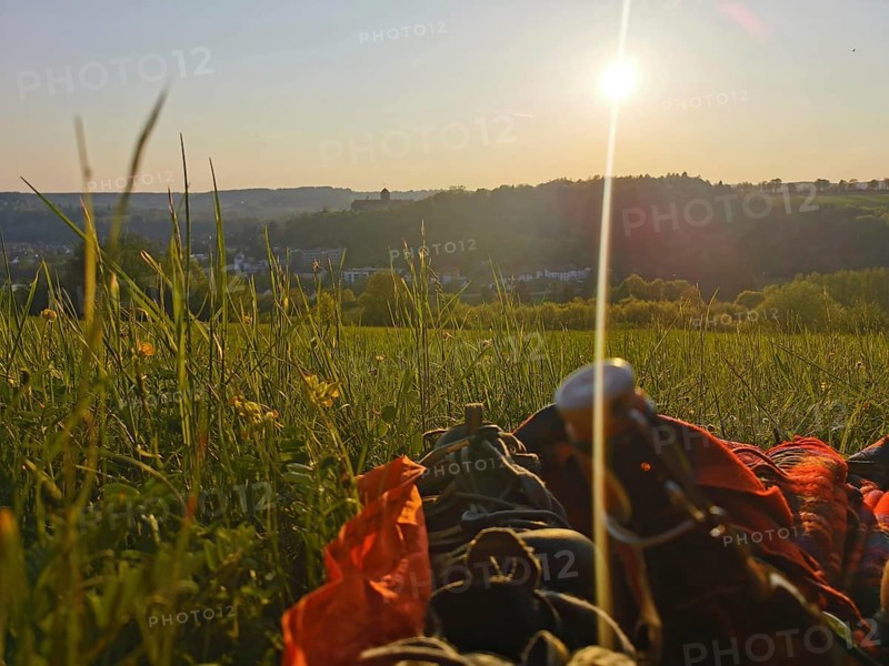 A picnic in a meadow as the sun sets and a panoramic view of the Rosenberg Fortress, Kronach, Frankenwald nature park Park