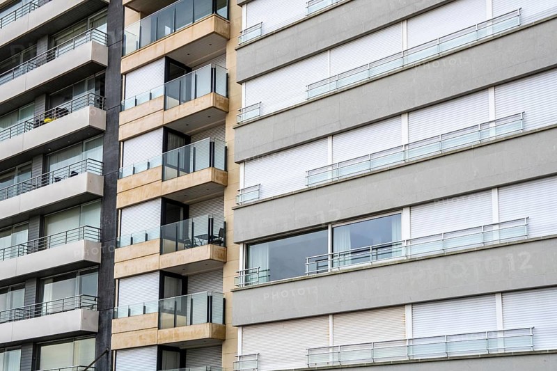Facades of residential buildings on Zeedijk-Knokke, beach promenade in Knokke-Heist, largely uninhabited in winter, on the North Sea beach, dreary winter day, mostly apartment buildings with rental or condominiums, high-rise buildings on the street, Belgium