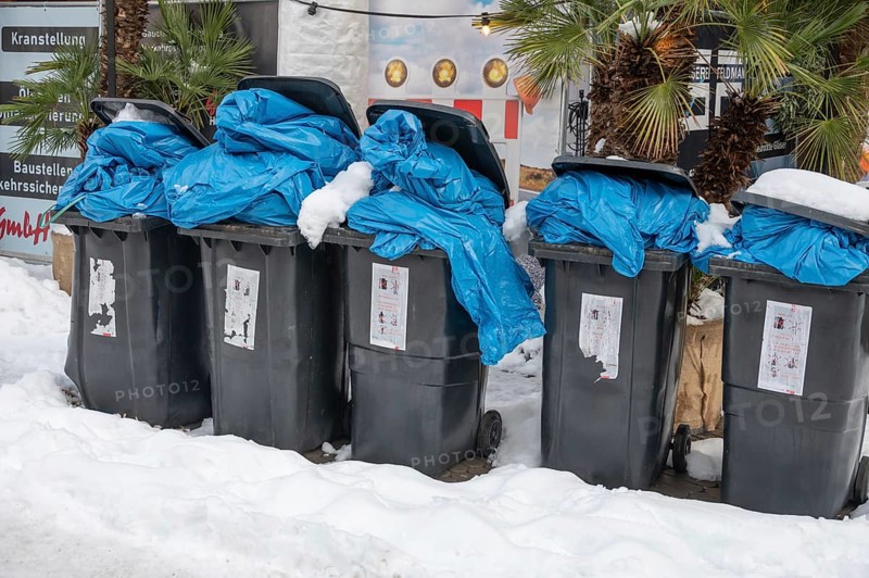 Overfilled garbage cans in the snow for collection, pedestrian zone, Nuremberg, Middle Franconia, Bavaria, Germany