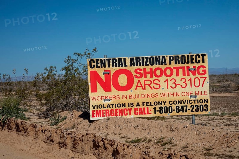 Buckeye, Arizona - A sign near the Central Arizona Project canal prohibits shooting because of workers in nearby buildings