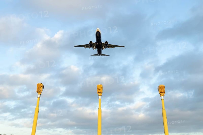 Boeing 737 commercial passenger airliner jet aircraft of Ryanair airways in flight on approach to land over runway lights at London Stansted airport, Essex, England, United Kingdom