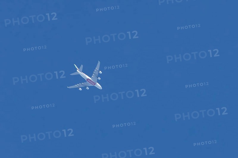 Airbus A380 commercial passenger airliner jet aircraft of Emirates airlines flying in a blue sky, England, United Kingdom