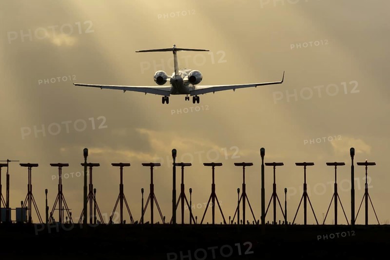 Executive business jet aircraft in flight on approach to land at sunset at London Stansted airport, Essex, England, United Kingdom