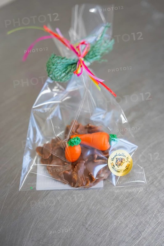 Chocolate snack with carrot decoration in a transparent bag, decorated with green gift ribbon, Easter production of regional products, Haselstaller Hof, Gechingen, Calw district, Germany