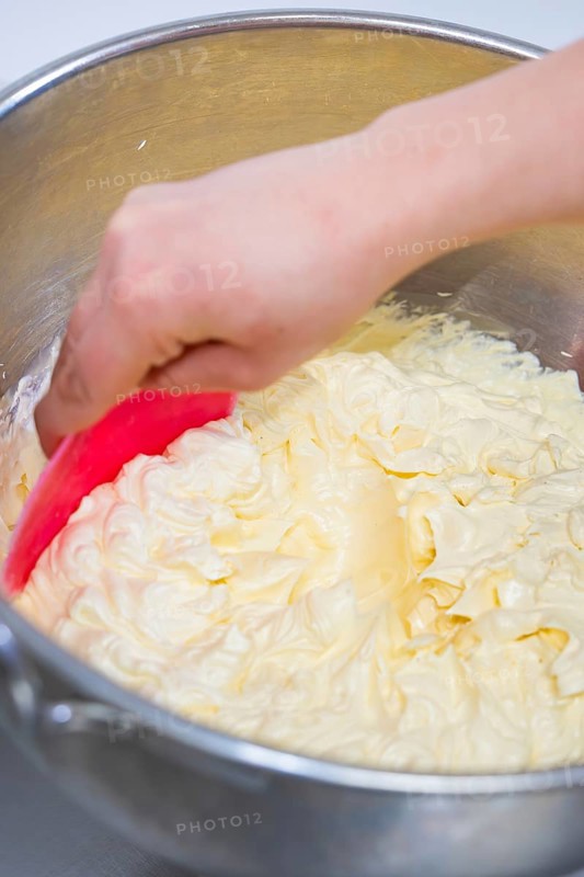 Hand stir buttercream in a metal bowl with a pink dough spatula, vegan cake production, Haselstaller Hof, Gechingen, Germany