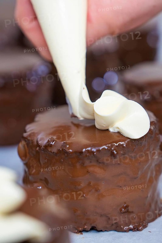 Hand decorated a chocolate cake with cream from a piping bag, vegan cake production, Haselstaller Hof, Gechingen, Germany
