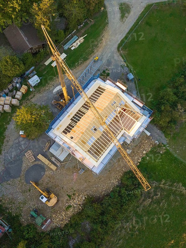 Aerial view of a construction site with crane and semi-finished building in rural area, timber house construction, Gechingen, Germany