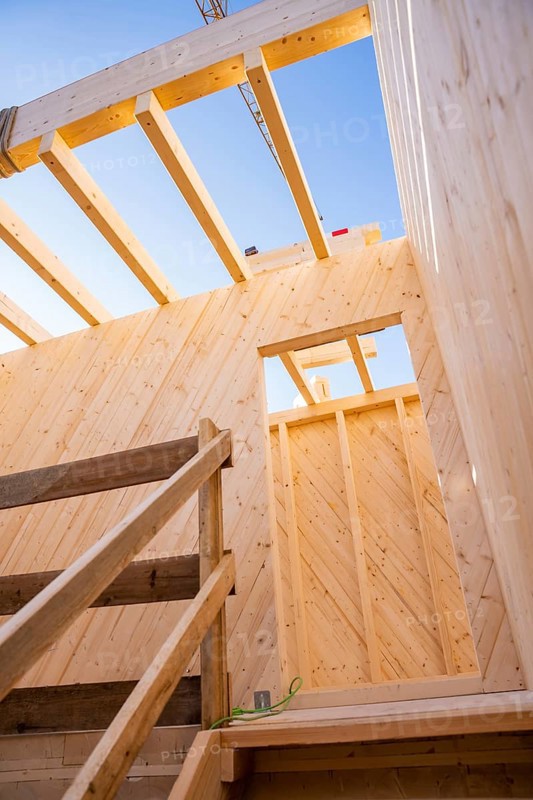 Looking up through the wooden structure of a building on blue sky, timber house construction, Gechingen, Germany