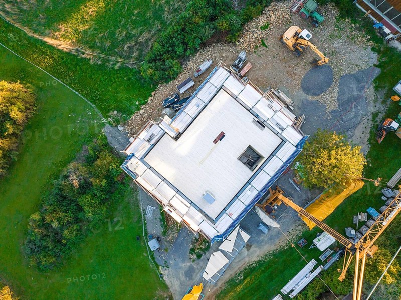 Aerial view of a construction site with building foundation and crane in a green landscape, timber house construction, Gechingen, Germany
