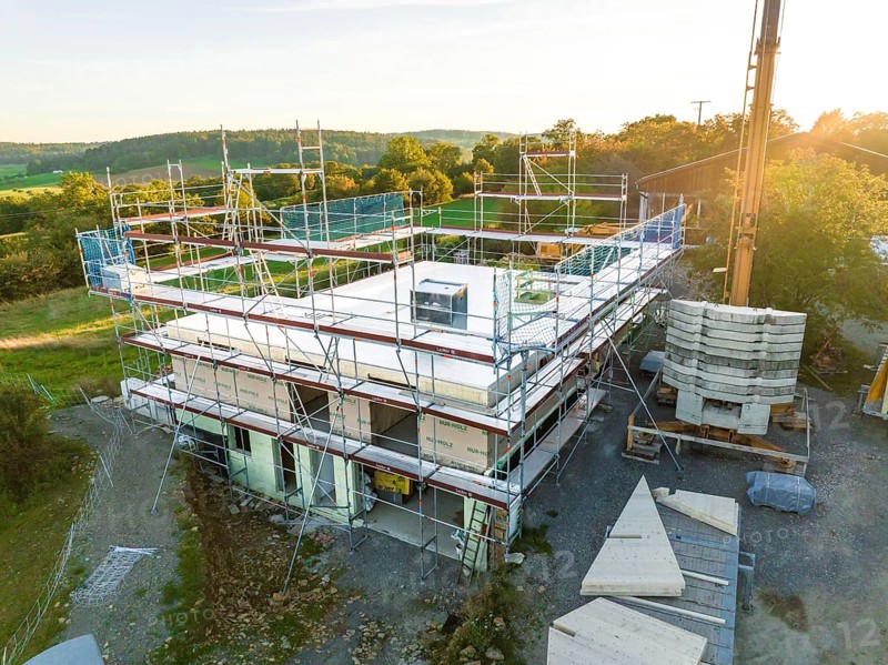 Building under construction with scaffolding in a rural area at sunset, timber house construction, Gechingen, Germany