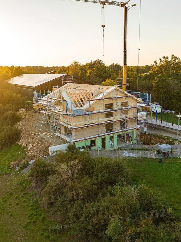 Building under construction, surrounded by scaffolding, at sunset in a rural area, timber house construction, Gechingen, Germany