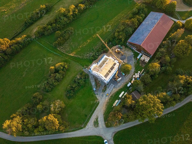 Aerial view of a construction site with a building under construction and solar roof in green landscape, timber house construction, Gechingen, Germany