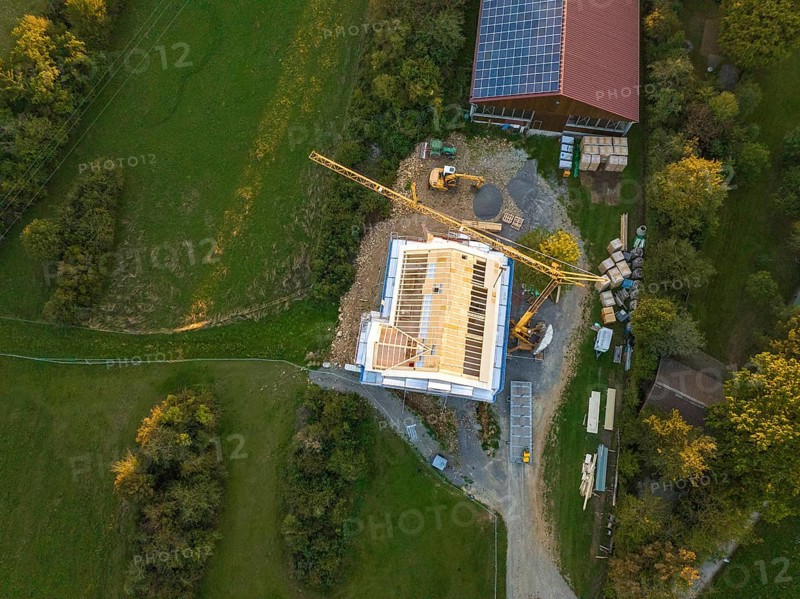 Aerial view of a construction site with a large construction building and solar system next door, timber house construction, Gechingen, Germany