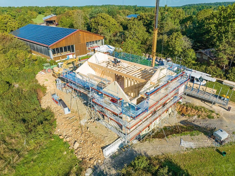 Bird's eye view of a construction site in a natural environment with solar building nearby, timber house construction, Gechingen, Germany