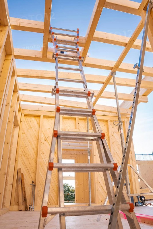 Interior view of a timber structure under construction, ladder leading upwards under blue sky, timber house construction, Gechingen, Germany