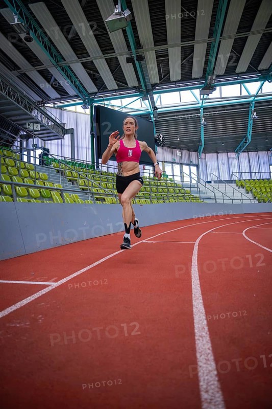 Female athlete sprints energetically on a red track in a sports complex, middle distance runner Katharina Jaiser, Sindelfingen Glass Palace, Germany