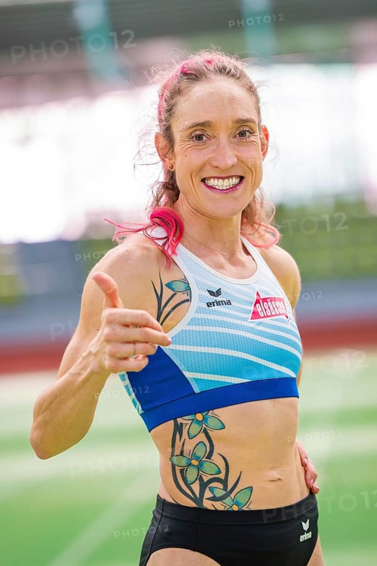 Woman showing thumbs up and smiling with tattoos in stadium, middle distance runner Katharina Jaiser, Sindelfingen Glass Palace, Germany