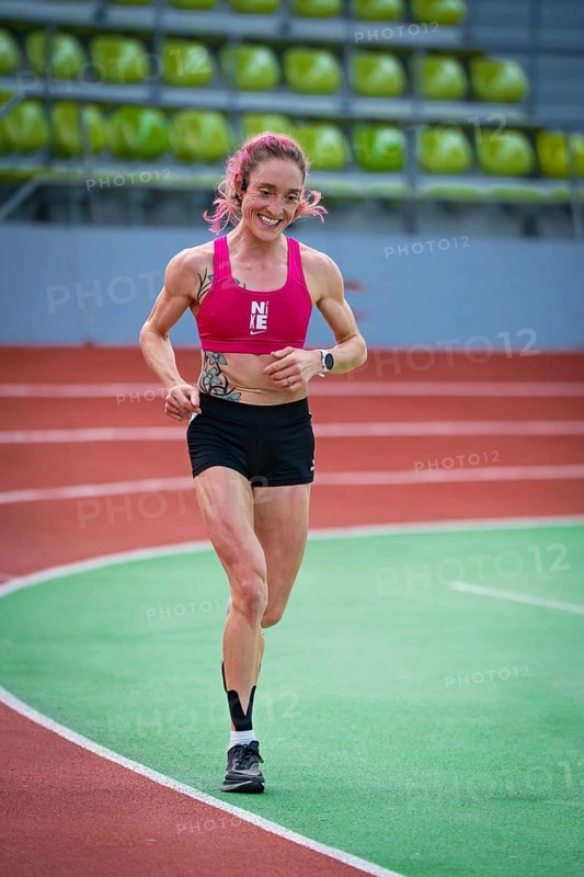 Determined, smiling woman running on an indoor track with visible enthusiasm, middle distance runner Katharina Jaiser, Sindelfingen Glass Palace, Germany