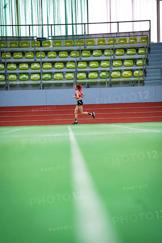Female athlete running alone on an extensive track in a hall, middle distance runner Katharina Jaiser, Sindelfingen Glass Palace, Germany