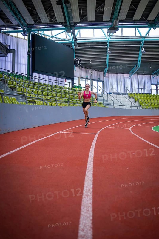 Woman running on a red indoor track in a stadium, middle distance runner Katharina Jaiser, Sindelfingen Glass Palace, Germany