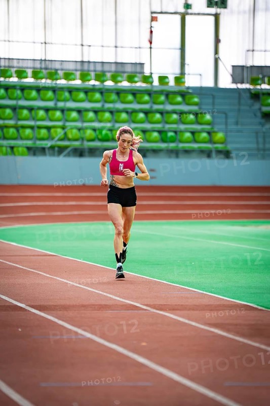 Sporty dressed woman running on an indoor track, showing speed and focus, middle distance runner Katharina Jaiser, Sindelfingen Glass Palace, Germany