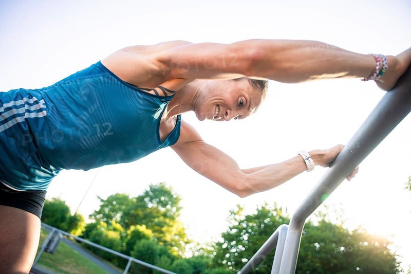 Woman bends over outdoor railings, concentrates on intensive training, middle distance runner Katharina Jaiser, Gechingen, Germany