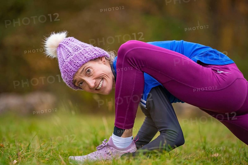 Woman wearing colorful clothes doing relaxation exercises in nature, smiling and showing joy, middle distance runner Katharina Jaiser, Gechingen, Germany