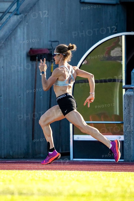 A woman in sporty clothes runs fast on a track in a stadium, middle distance runner Katharina Jaiser, Gechingen, Germany