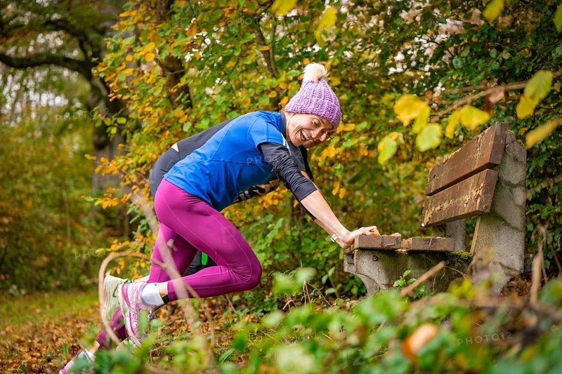 Woman stretching on a bench in an autumnal park, middle distance runner Katharina Jaiser, Gechingen, Germany