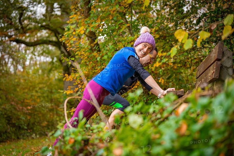 Woman wearing colorful sportswear smiles during a workout in autumn forest, middle distance runner Katharina Jaiser, Gechingen, Germany