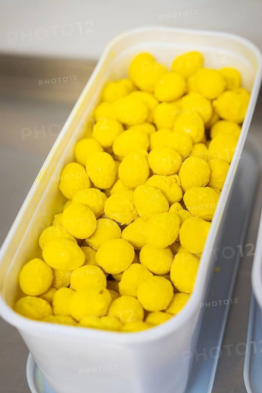 Many yellow balls in a plastic container, presented industrially, chocolate quail eggs, Easter production, Haselstaller Hof, Gechingen, Germany