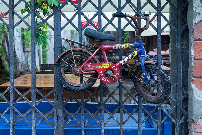 Old children's bicycle on an iron grid, Krakow, Poland