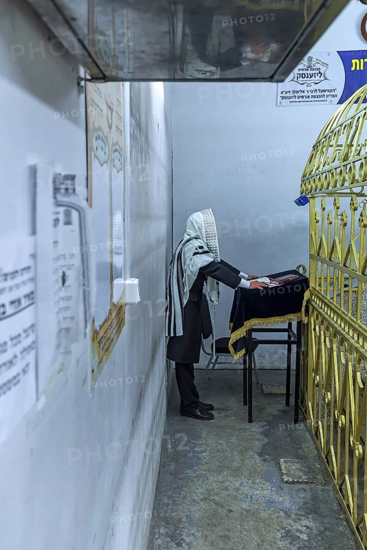 Orthodox Jew praying at the grave of Hasidic Rabbi Elimelech in Lezajsk Jewish Cemetery, Poland