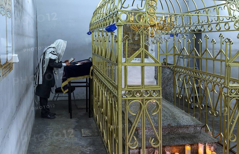 Orthodox Jew praying at the grave of Hasidic Rabbi Elimelech in Lezajsk Jewish Cemetery, Poland
