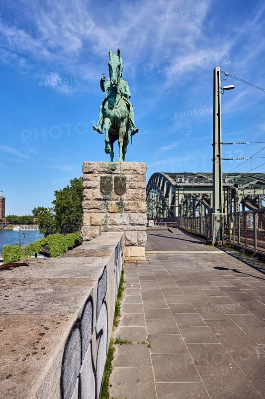Equestrian statue of Emperor Frederick III, sandstone wall, Hohenzollern bridge, arched bridge, steel arches, trees, blue sky, cirrus clouds, Cologne, district-free city, North Rhine-Westphalia, Germany
