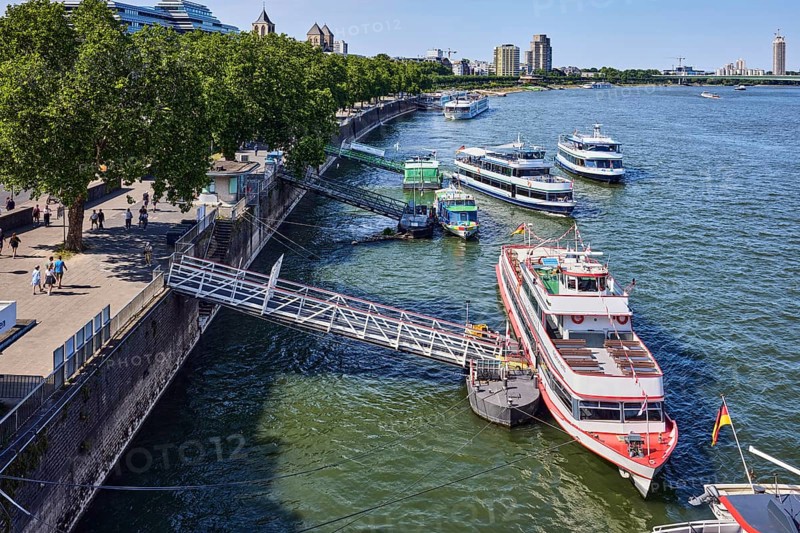 Rhine river, general architecture, Zoobrücke car bridge, footpath and cycle path, waterfront, boat launch, gangway, wharf, excursion boats, pedestrians as accessories, trees, bird's-eye view, blue sky, cloudless, potion yard, Cologne, district-free city, North Rhine-Westphalia, Germany