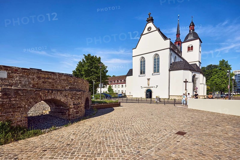 Historic railway hub, Alt St. Heribert church, cobblestone walkway, trees, pedestrians as accessories, blue sky, cirrus clouds, Urbanstraße, Kennedy-Ufer, Cologne, district-free city, North Rhine-Westphalia, Germany
