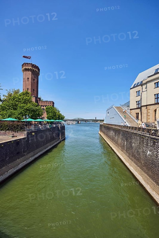 Rhine river, historic port, Rheinauhafen, quay wall, defense tower, Malakoff tower, building, outdoor area of a restaurant, trees, blue sky, cloudless, Cologne, district-free city, North Rhine-Westphalia, Germany