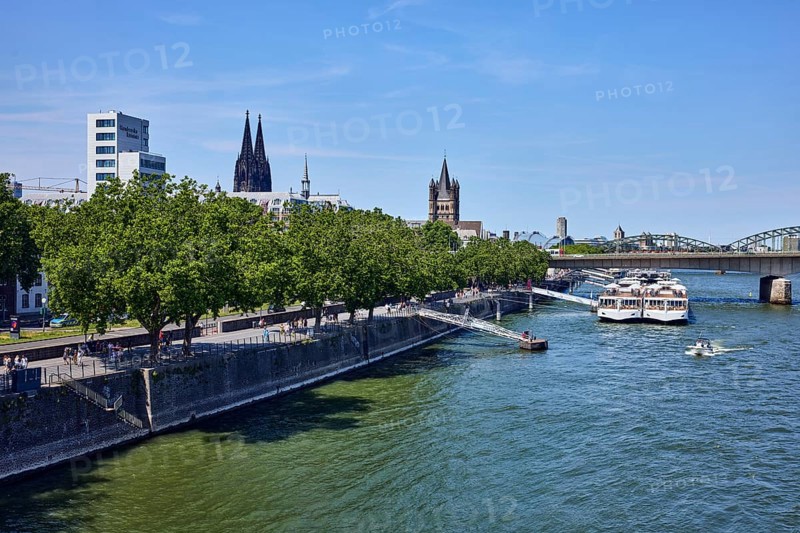 Rhine river, high-rise building, chamber of crafts, church towers of Cologne Cathedral and Groß St. Martin, bridge, sightseeing boats, boat launch, quay wall, trees, blue sky, cloudless, Deutz bridge, Leystapelwerft, Cologne, district-free city, North Rhine-Westphalia, Germany