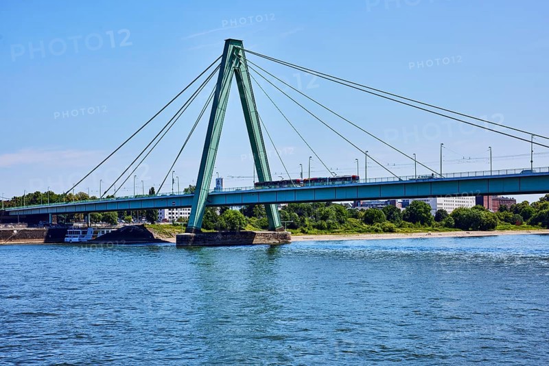 Severinsbrücke, architect Gerd Lohmer, bridge, cable-stayed bridge, bridge pillars, bridge ropes, bridge pylon, lantern, tram, trees, blue sky, cloudless, Cologne, district-free city, North Rhine-Westphalia, Germany