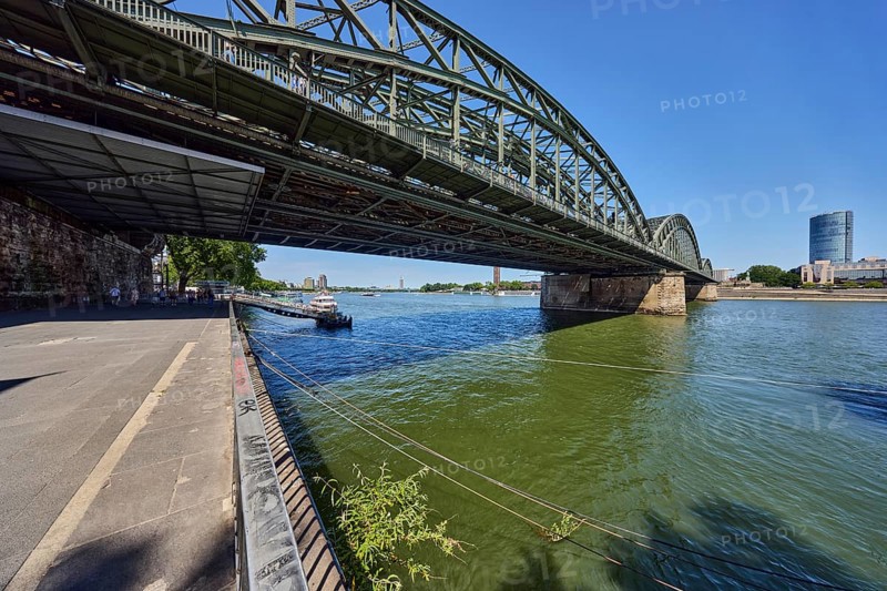 Rhine river, Hohenzollern Bridge pedestrian and railway bridge, steel arches, MaxCologne high-rise building, general architecture, waterfront, metal railings, blue sky, cloudless, Trankgassenwerft, Cologne, district-free city, North Rhine-Westphalia, Germany