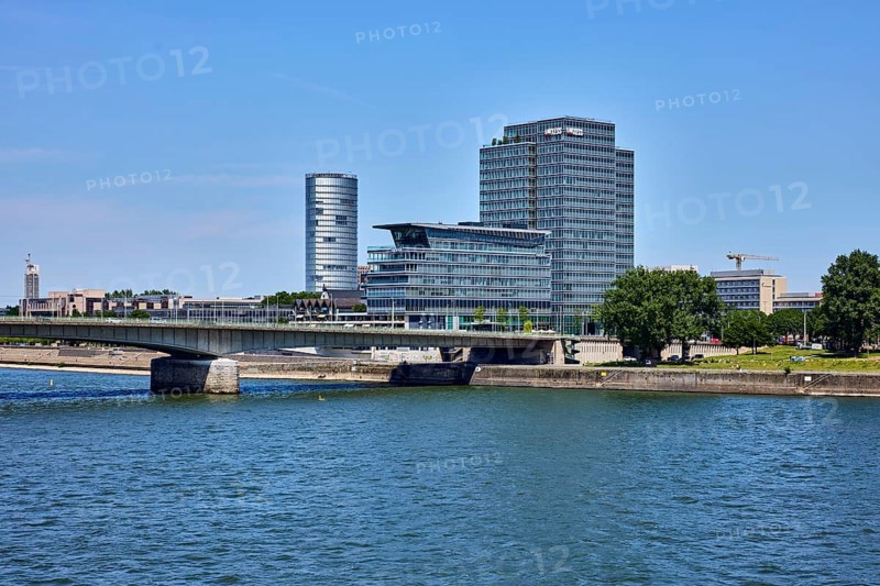 Rhine river, KölnTriangle and MaxCologne skyscrapers, Lanxess, corporate headquarters, car bridge and footbridge Deutzer Brücke, trees, water surface with small waves, blue sky, cloudless, Cologne, district-free city, North Rhine-Westphalia, Germany