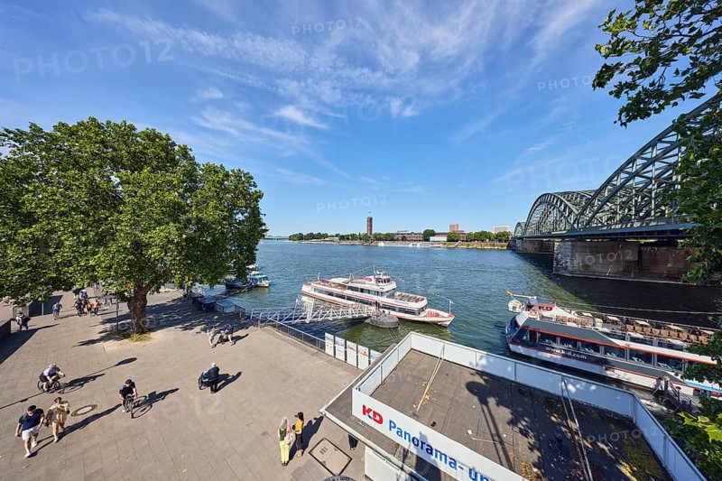 Rhine river, pedestrian and railway bridge Hohenzollern bridge, arched bridge, general architecture, waterfront, boat launch, gangway, wharf, excursion boats, Cologne-Düsseldorfer Deutsche Rheinschiffahrt GmbH, footpath, pedestrians and cyclists as secondary motif, trees, bird's-eye view, blue sky, cirrus clouds, Trankgassenwerft, Cologne, district-free city, North Rhine-Westphalia, Germany