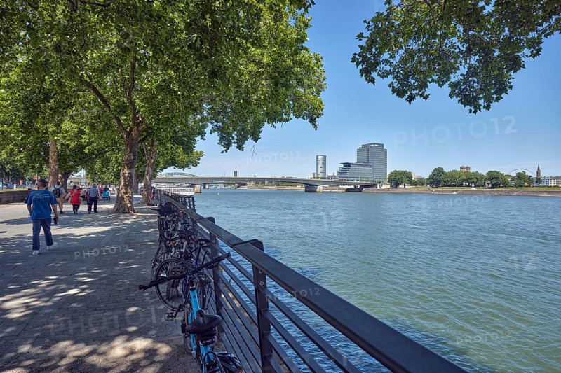 Rhine river, general architecture, MaxCologne high-rise building, bridge, Deutz bridge, metal railings, waterfront, trees, bicycles, pedestrians as accessories, image processing contrasts, blue sky, cloudless, Leystapelwerft, Cologne, district-free city, North Rhine-Westphalia, Germany