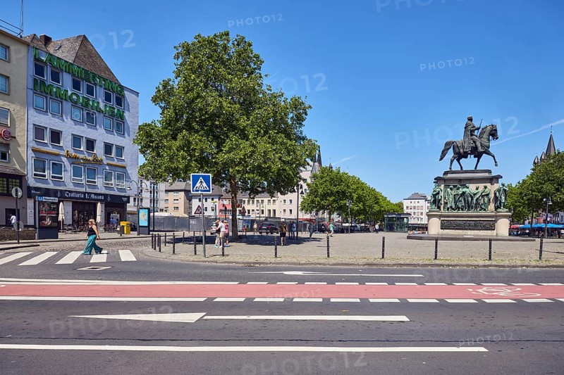 Memorial of Frederick William III of Prussia, equestrian statue, general architecture, residential buildings and commercial buildings, street, pedestrian crossing, road markings zebra crossings, lanes, cycle path and directional arrows, trees, blue sky, cloudless, confluence Heumarkt with Deutzer Brücke and Augustinerstraße, Cologne, district-free city, North Rhine-Westphalia, Germany