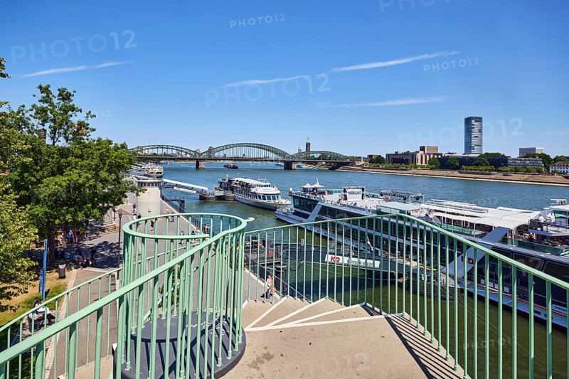 Rhine river, metal railings, outdoor spiral staircase, general architecture, skyscrapers, modern buildings, excursion boats, pedestrian and railway bridge Hohenzollern Bridge, trees, elevated perspective, blue sky, cirrus clouds, Deutz bridge, Cologne, district-free city, North Rhine-Westphalia, Germany