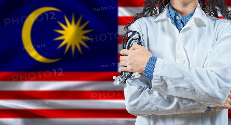 Malaysian healthcare professional with Malaysia flag background. Professional doctor holding stethoscope on Malaysia flag background