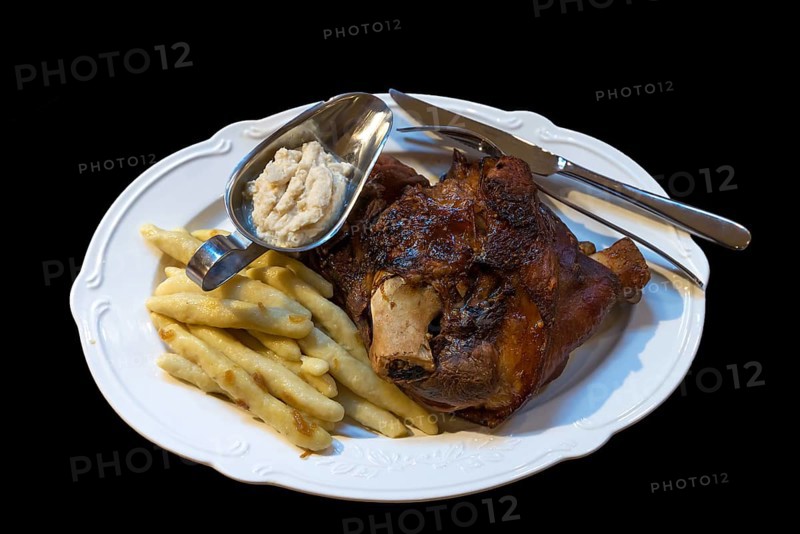 Pork knuckle, French fries and horseradish served on a plate, Ukraine