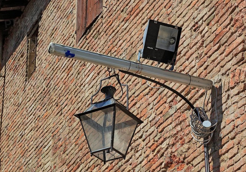 Historic lantern and modern halogen spotlight in La Rocca, Novellara Castle, Emilia-Romagna, Italy